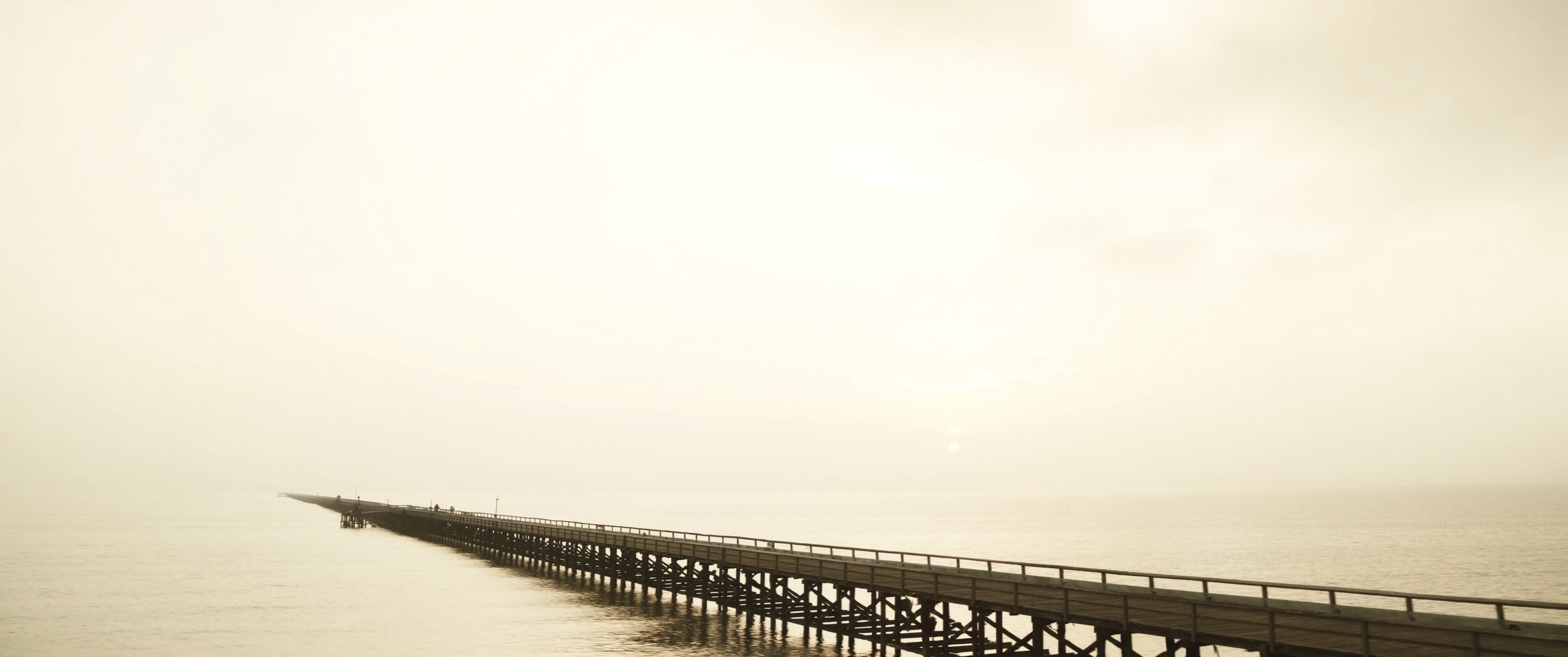 Timber jetty over calm water at dawn
