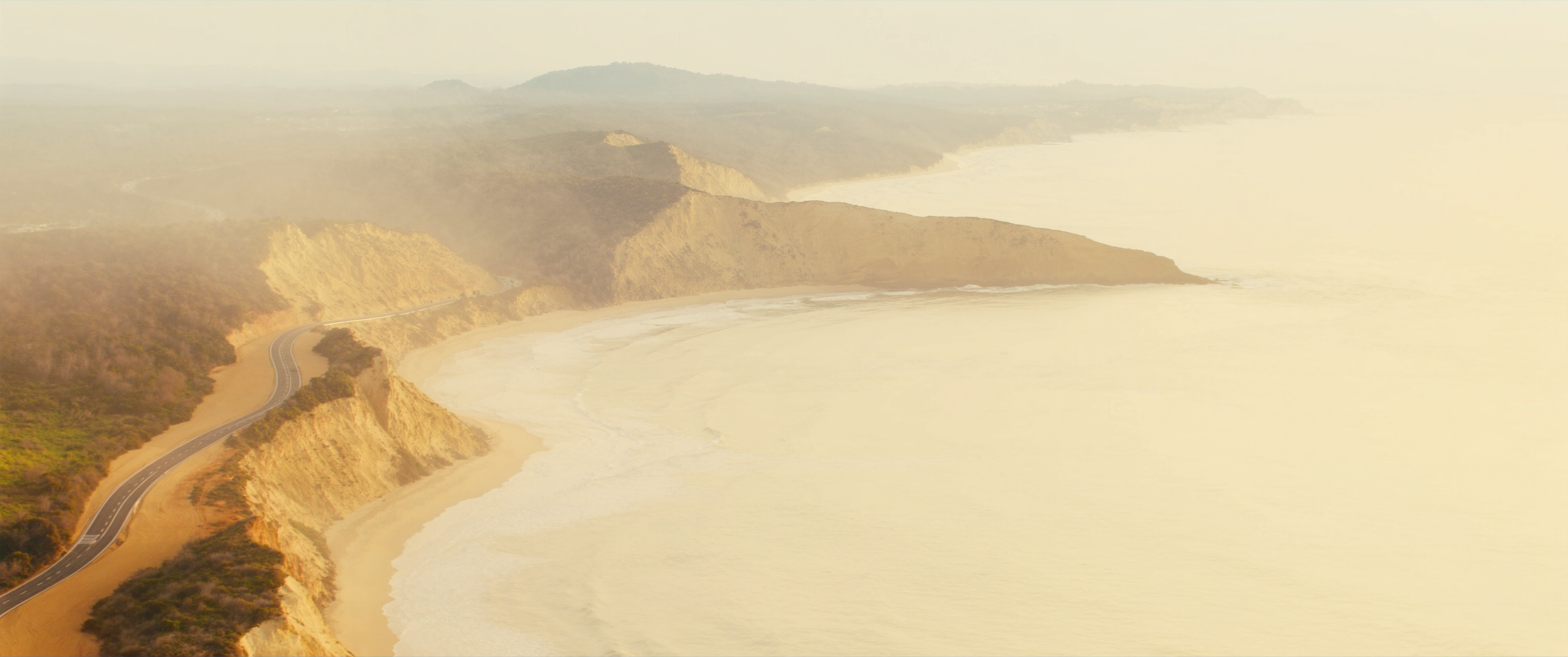 Coastal road along golden headlands at sunrise